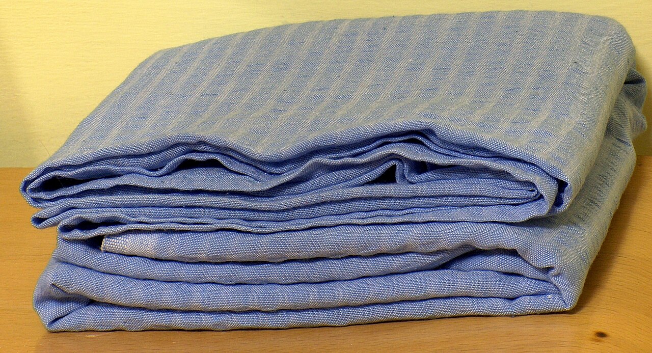 Wit laken, strak opgemaakt over een matras